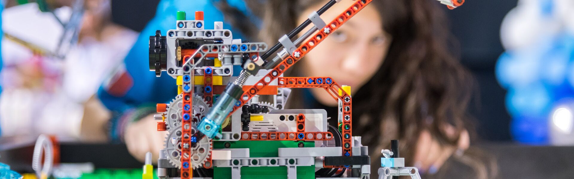 Ученица RoLab настраивает робота на соревнованиях FIRST LEGO League